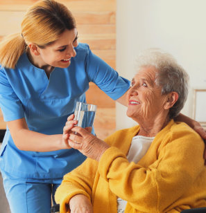 caregiver give her patient a glass of water